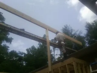 Carpenter setting a ridge beam over a new addition frame — Ice Dam Removal by Roofing Brothers in East Brady