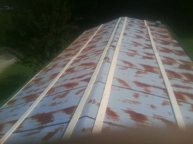 Rusted metal roof panels with new wood purlins before replacement — Storm Damage Roof Repair in East Brady by Roofing Brothers