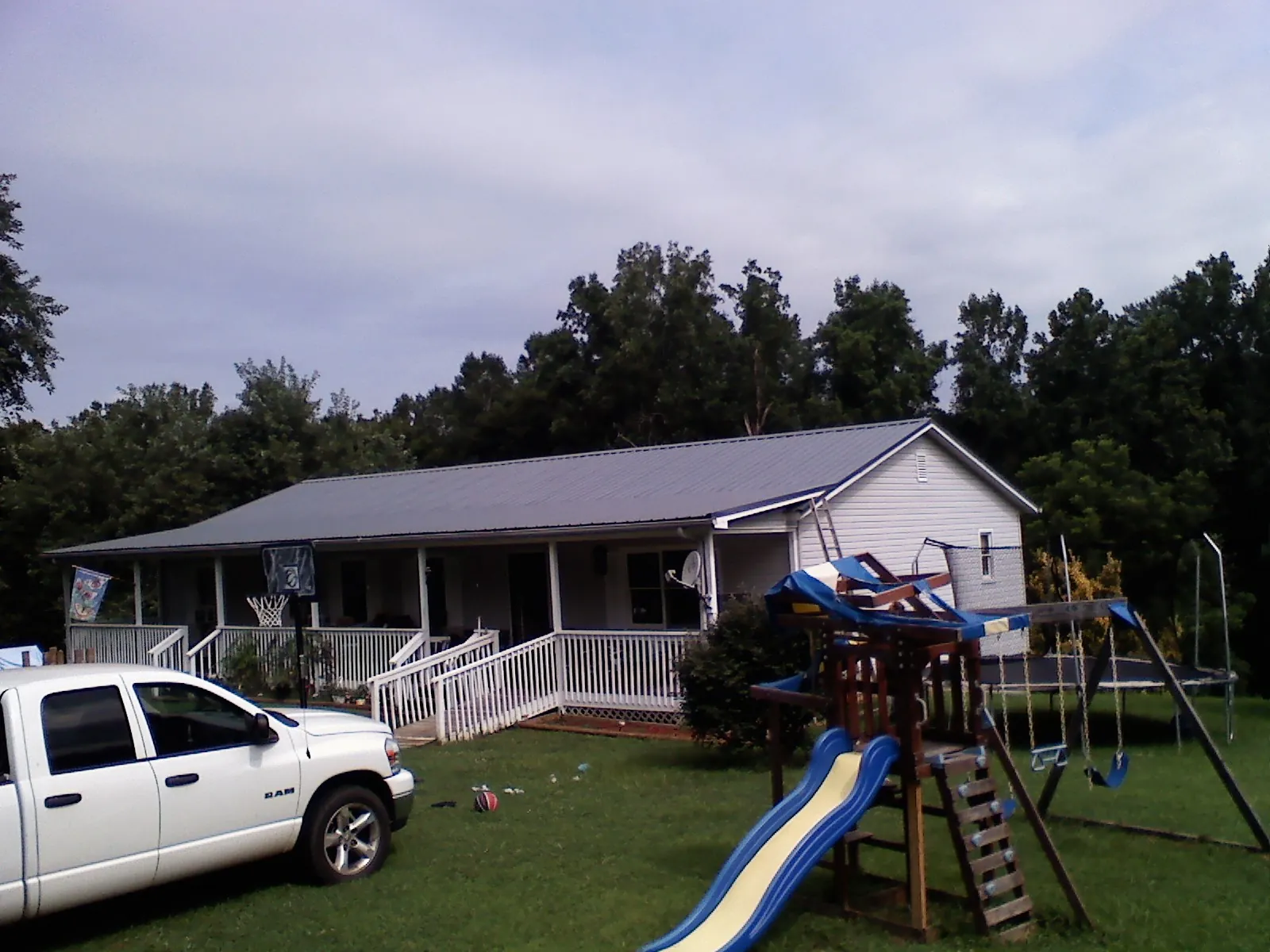 Dark metal roof on a country home with a full length front porch in East Brady