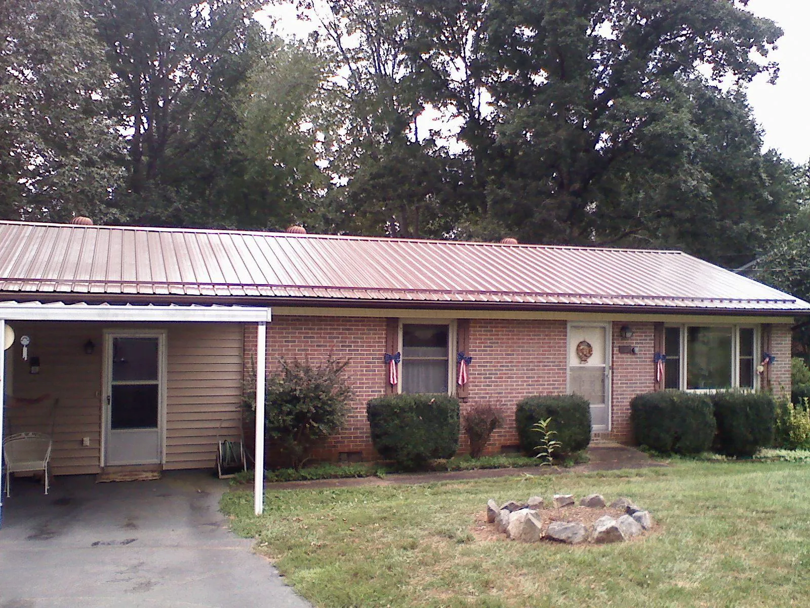 Bronze metal roof and carport on a brick ranch home — Roof Repair work by our crew in East Brady